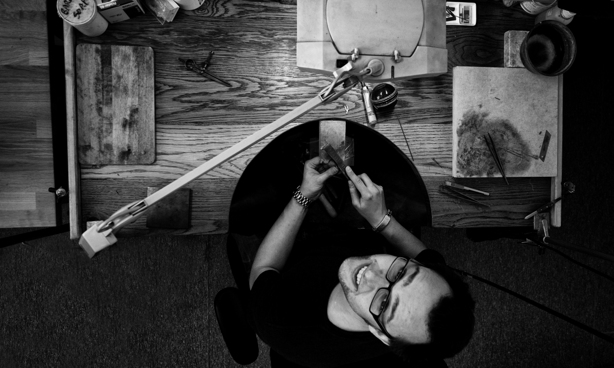 By Dana Robertson Creative Director and Founder of Neon. The Goldsmiths' Centre Creativity Craftsmanship Community workshop reportage 'bench from above'. The Goldsmiths' Centre, Creativity, Craftsmanship, Community. Three words encapsulate the values of The Goldsmiths’ Centre. Creativity encompasses Centre’s commitment to encouraging and inspiring creativity in the design and making of beautiful objects. Craftsmanship refers to the Centre’s important role as a repository of knowledge, building on centuries of experience. Community expresses an important aspiration of the Centre; to create a centre of excellence, a hub where like-minded people and businesses come together to share ideas, collaborate and build relationships, and to become a place of inspiration. These values are married with a brand identity which reflects the Centre’s heritage, with the use of a monochromatic coat of arms of The Goldsmiths’ Company. A strong yellow - the common heraldic substitution for gold – helps create a vibrant, contemporary look and feel, positioning the Centre as a new future-facing organisation, distinctly separate from the more traditional Goldsmiths’ Company. The yellow appears as a crafted information plate on all materials – helping to clearly state the purpose of each piece of comms with the main headline elegantly stencilled into the plate. The new identity was rolled out across all manner of media, including literature, signage and website. – Idea, art direction and design by Neon Design & Branding Consultancy www.neon-creative.com